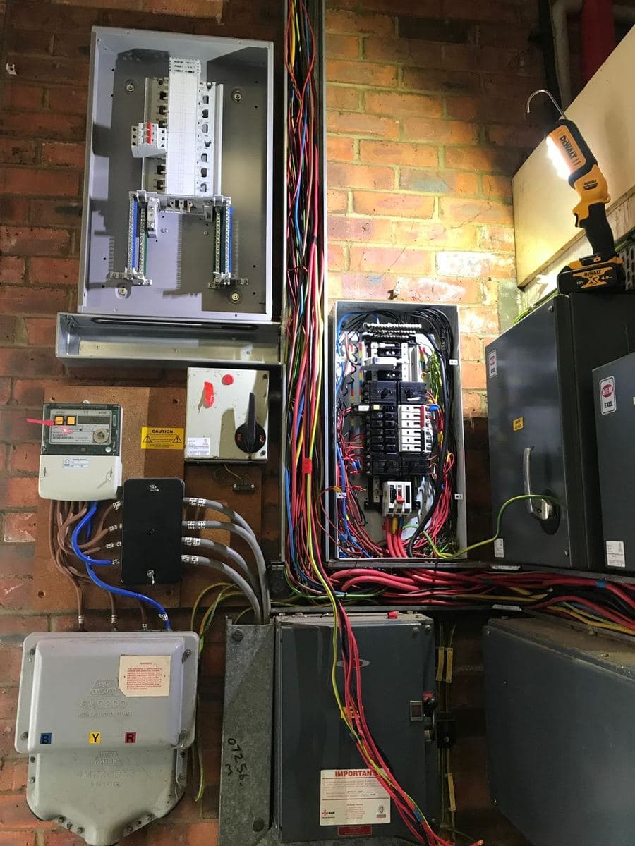Commercial intake before a board change: three-phase meter, cut-out, old board and switchgear
