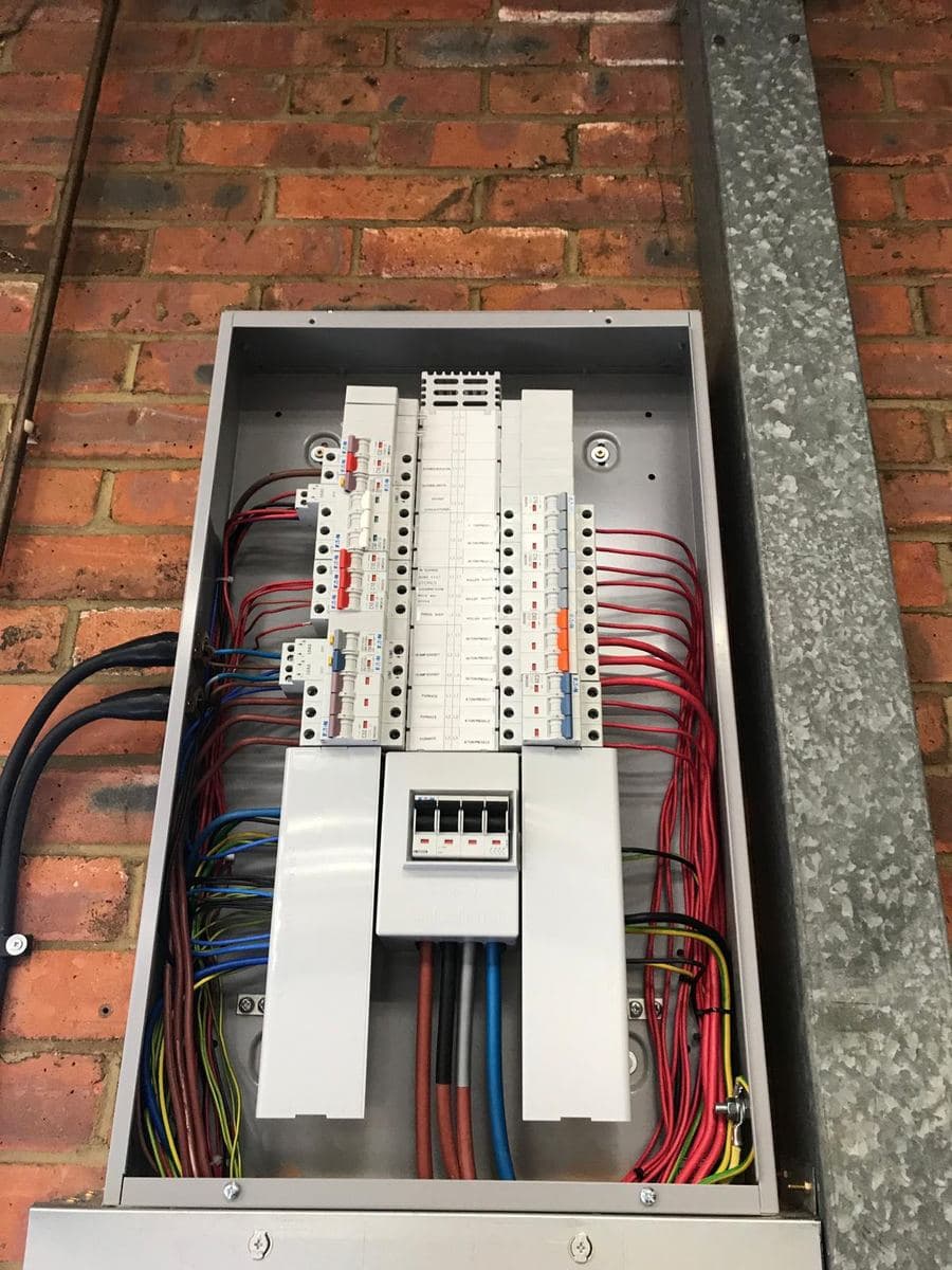 Finished three-phase distribution board, neatly wired with labelled circuits
